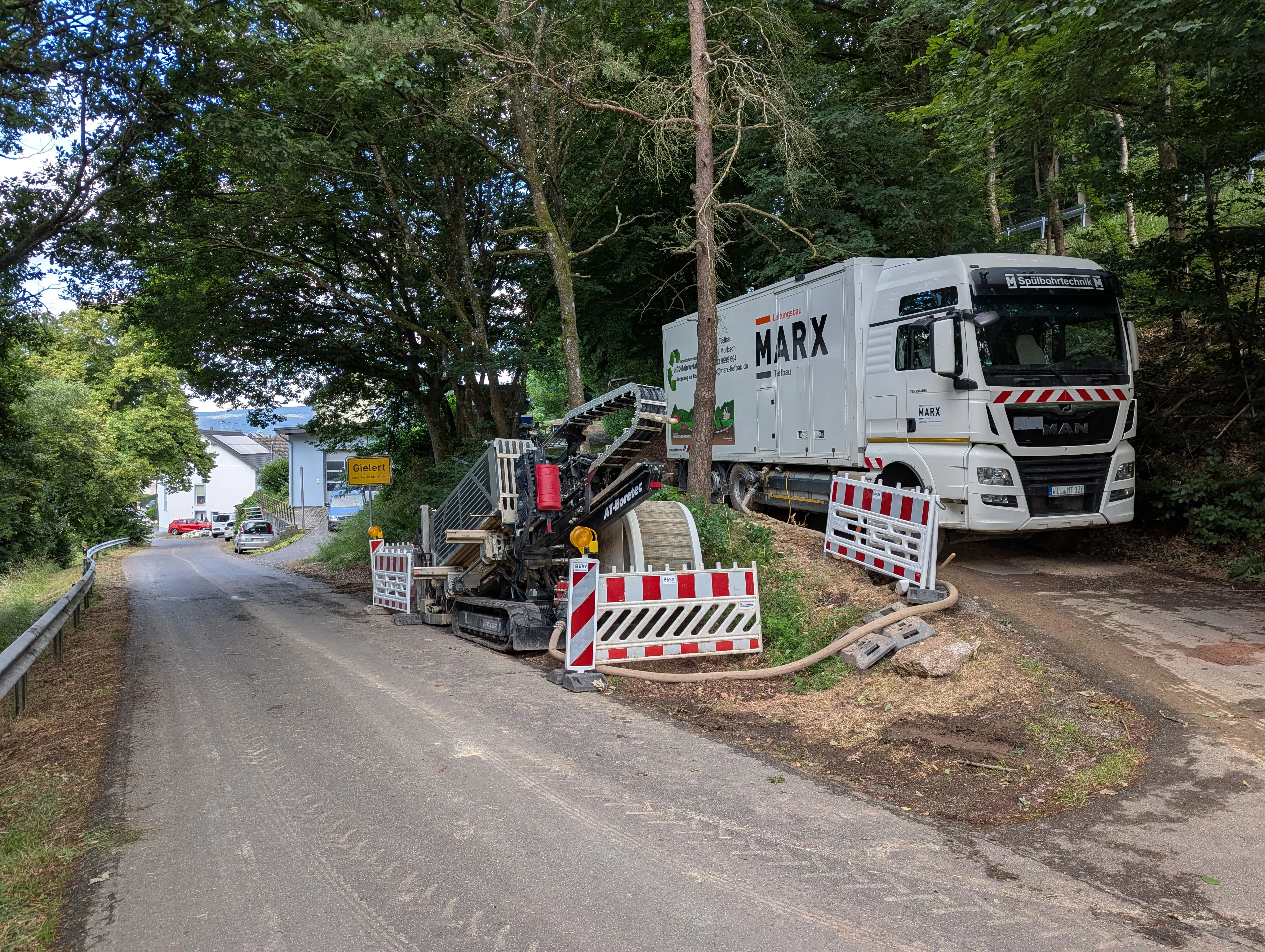 Baustelle mit Bohrgerät und Lkw für den Glasfaserausbau im Ort